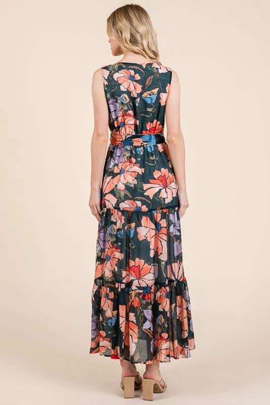 Woman wearing a floral tie waist sleeveless maxi dress with tiered skirt