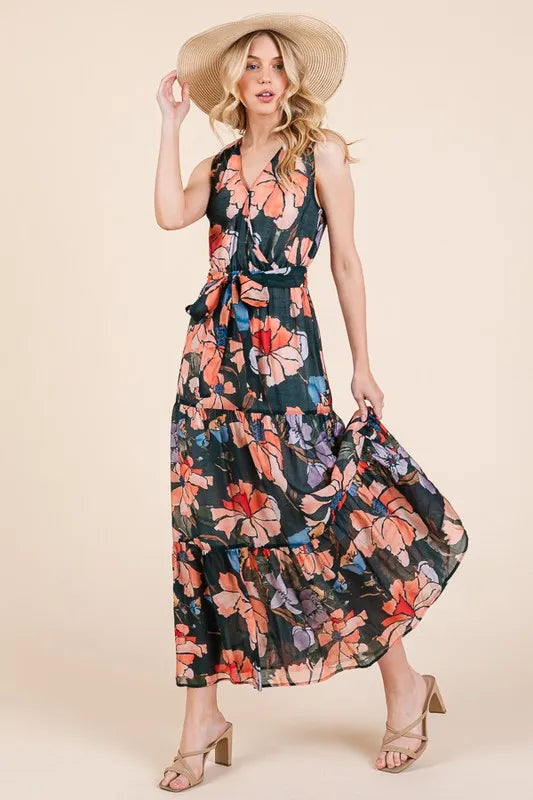 Woman wearing a floral tie waist sleeveless maxi dress with tiered skirt