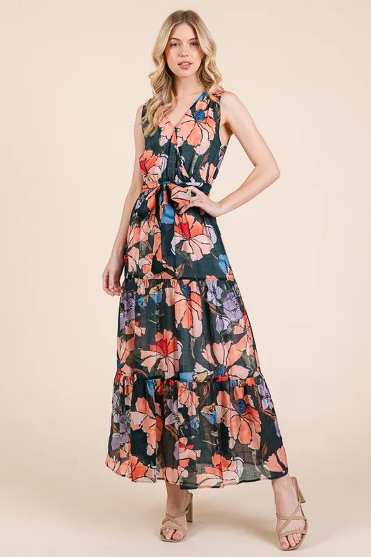 Woman wearing a floral tie waist sleeveless maxi dress with tiered skirt