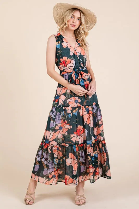 Woman wearing a floral tie waist sleeveless maxi dress with tiered skirt
