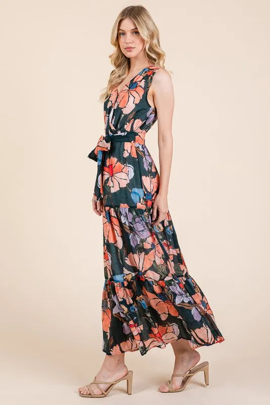 Woman wearing a floral tie waist sleeveless maxi dress with tiered skirt