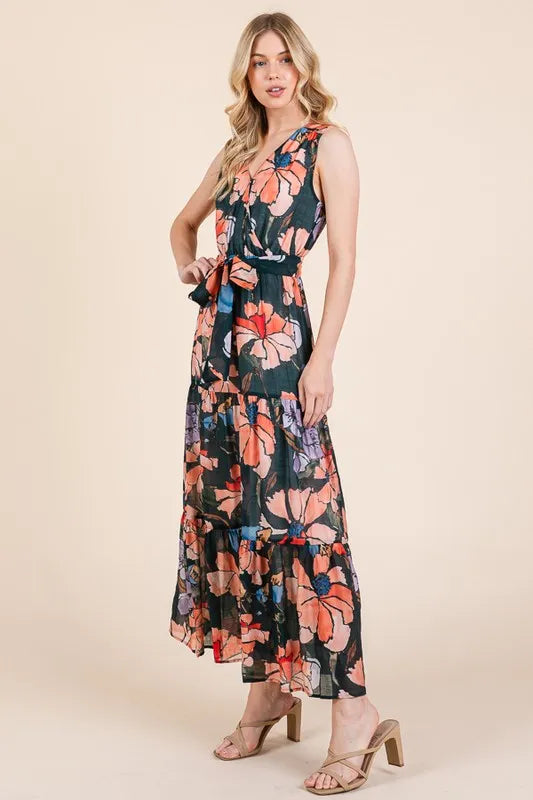 Woman wearing a floral tie waist sleeveless maxi dress with tiered skirt